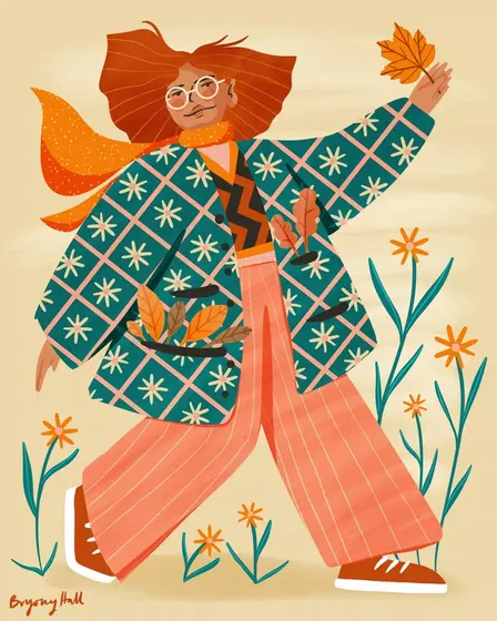 Woman in a patterned jacket walking through autumn leaves