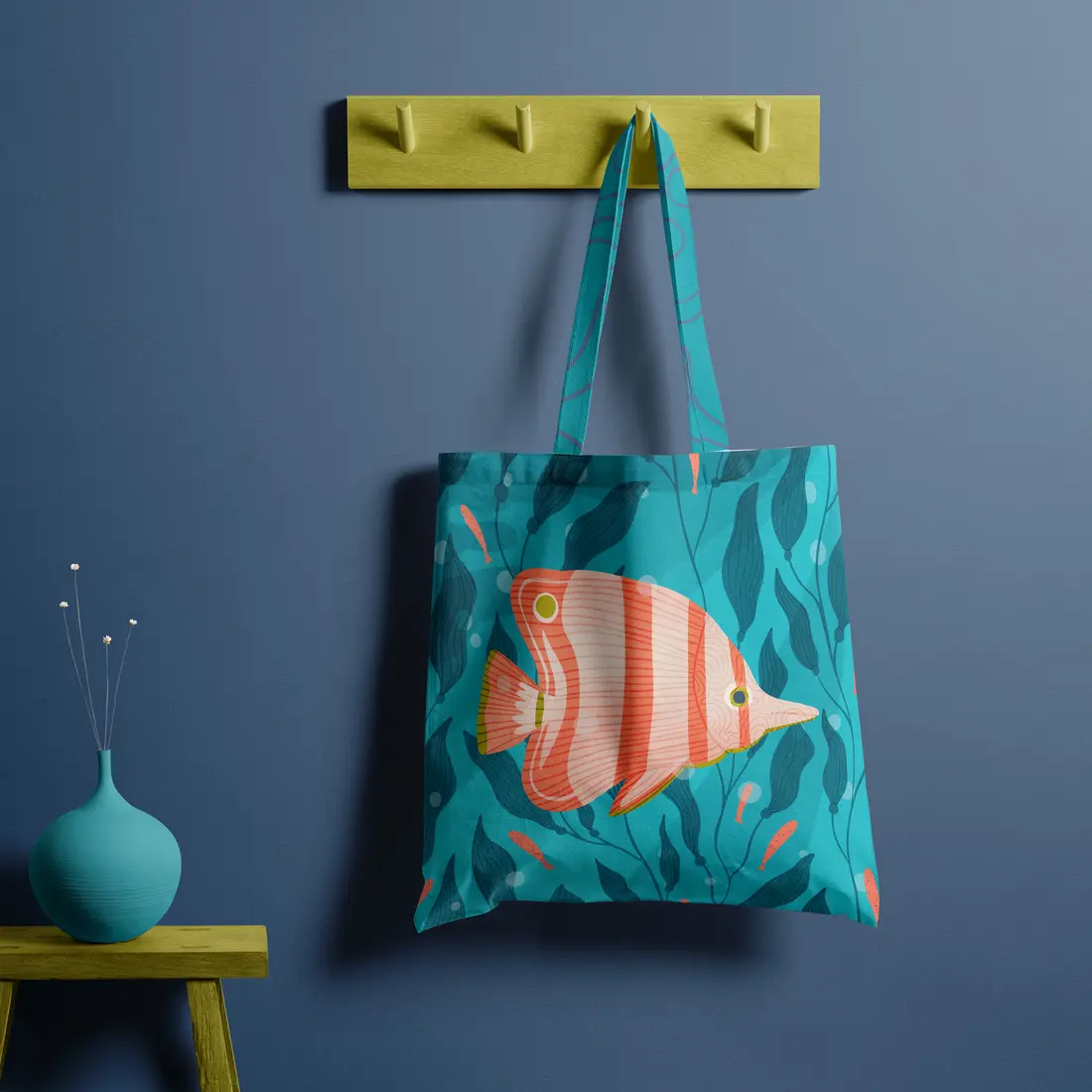 Tote bag with a striped coral fish among kelp, hanging on a yellow peg rail